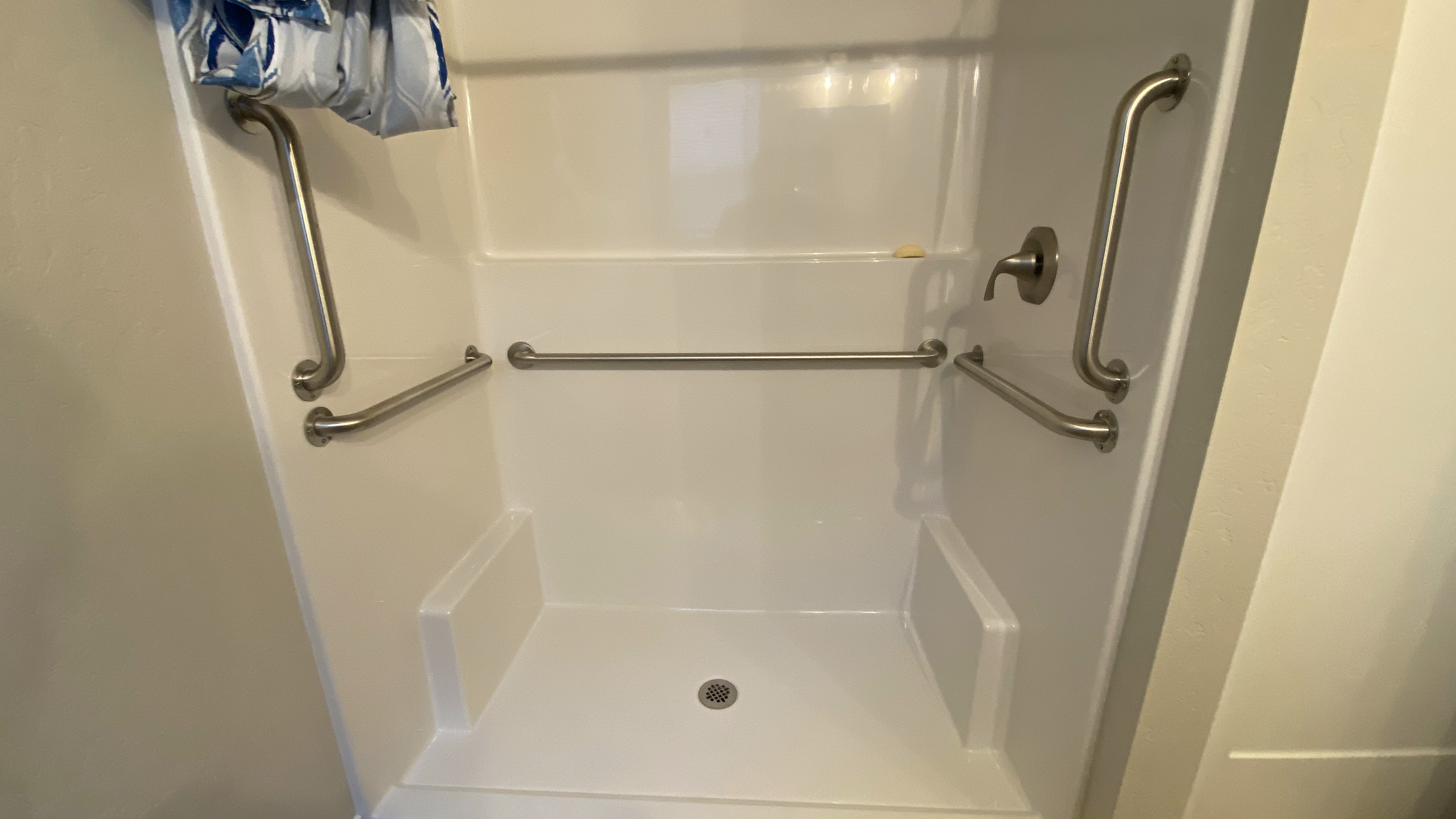 Marble tile shower with grab bars